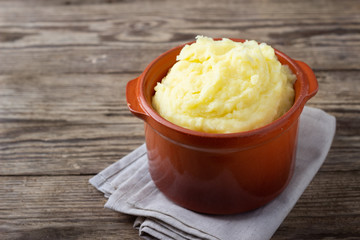 Canvas Print - Mashed potatoes in a clay pot, vintage wood background, rustic style.