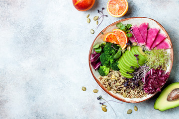 Vegan, detox Buddha bowl with quinoa, micro greens, avocado, blood orange, broccoli, watermelon radish, alfalfa seed sprouts. Top view, flat lay, copy space