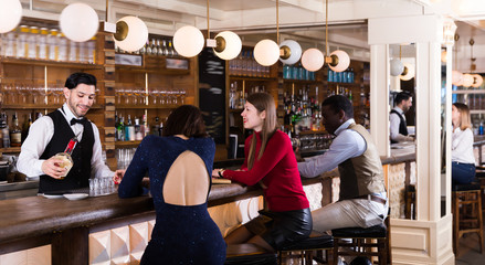 Happy people are relaxing near bar counter