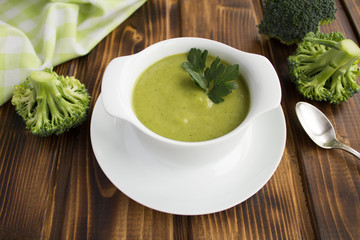 Wall Mural - Vegetarian  broccoli puree soup in th white bowl on the brown  wooden background