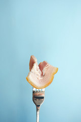 Wall Mural - Bacon on the fork. Blue background with empty place for text