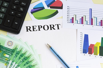 Preparation of financial report on the results of work. Money, calculator, pen, color charts and diagrams on the table