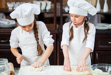 two girls make flour dough.