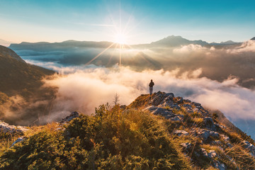 successful hiker enjoying at top of mountain above clouds