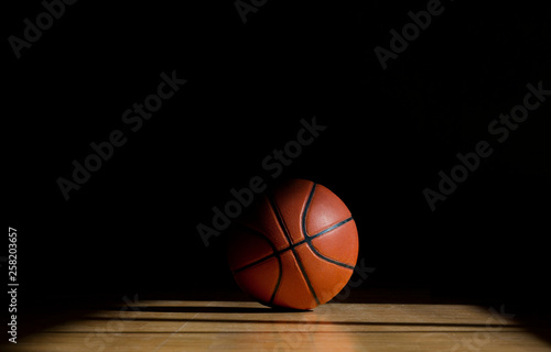 Basketball ball on the parquet with black background