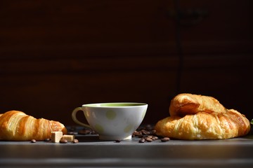 Wall Mural - Coffee composition. Cup of coffee, croissants, sugar slices on a dark background 