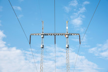 Electric Poles With Wires And Cables Set On A Bright Blue Daylight Sky.