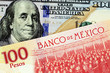 A close up image of a new American one hundred dollar bill with a Mexican one hundred peso bank note in macro