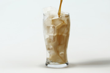 Cola in glass with ice on white background