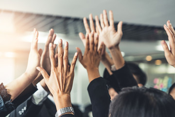 Wall Mural - Many happy business people raise hands together with joy and success. Company employee celebrate after finishing successful work project. Corporate partnership and achievement concept.