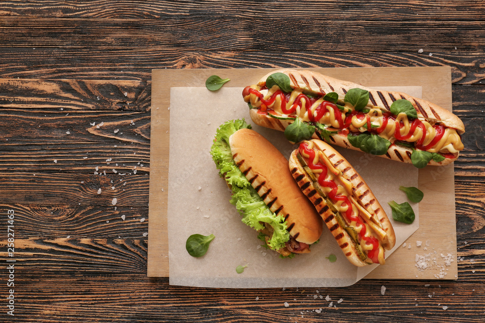 Tasty hot dogs on wooden table