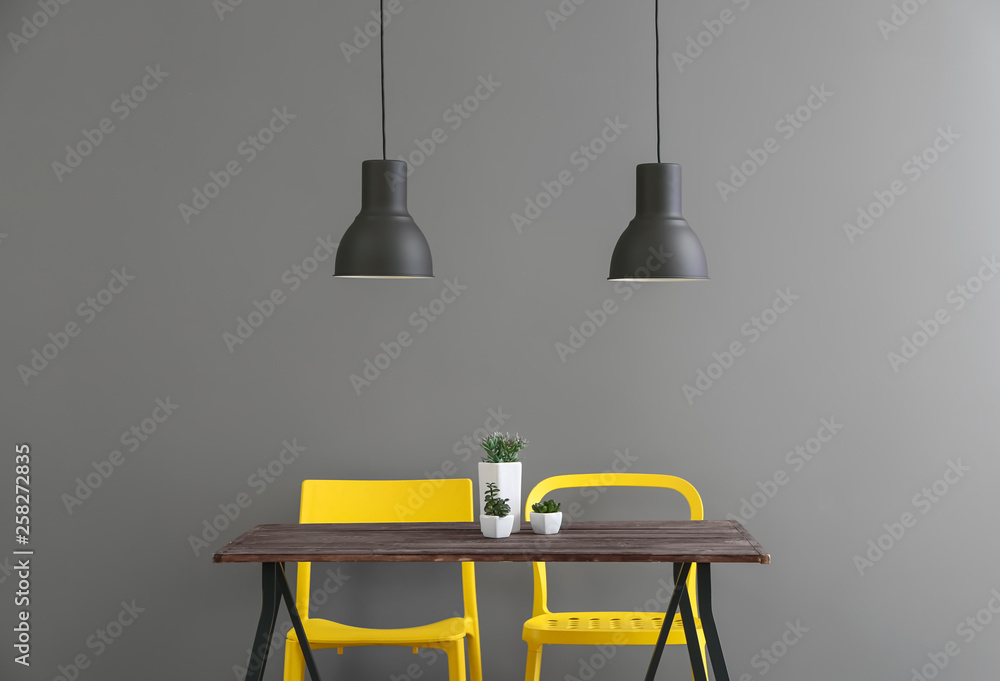 Chairs and table near grey wall in room