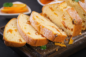 Orange cake with dried apricots and powdered sugar.