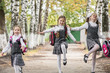 © Kiryakova Anna - Smiling young children in a school uniform run and bounce happily on the road in the park