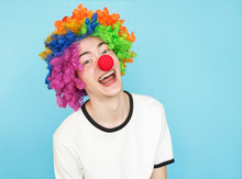 Young Funny Male Teenager In White T-shirt On Blue Background In Clown Wig