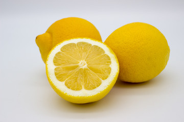 Wall Mural - Two lemons and a half of a lemon isolated image on a white background