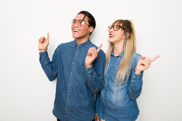 Wall Mural - Young couple with glasses pointing with the index finger a great idea