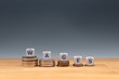 © Fokussiert - Symbol for declining wages. Dice placed on stacks of coins form the word 'WAGES'.