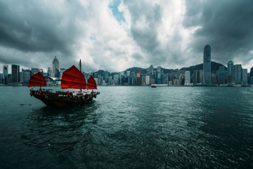 Fototapete - Hong Kong City skyline with tourist sailboat. View from across Victoria Harbor Hong Kong.