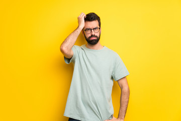 Wall Mural - Man with beard and green shirt with an expression of frustration and not understanding