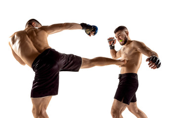 MMA. Two professional fightesr punching or boxing isolated on white studio background. Couple of fit muscular caucasian athletes or boxers fighting. Sport, competition, excitement and human emotions