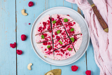Wall Mural - Vegan raw raspberry nut cheesecake on a light  background. Healthy vegan food concept.  Sugar, dairy and gluten free dessert