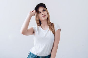 Attractive girl in a white t-shirt and a baseball cap