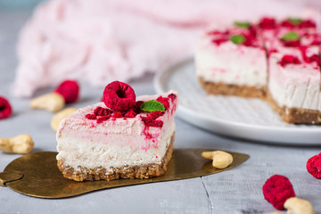 Vegan raw raspberry nut cheesecake on a light  background. Healthy vegan food concept.  Sugar, dairy and gluten free dessert