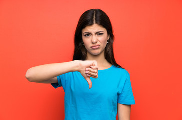 teenager girl with blue shirt showing thumb down sign