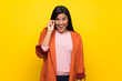 © luismolinero - Young Colombian girl over yellow wall with glasses and surprised