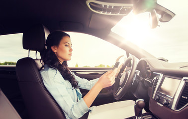 Poster - safety, road trip, technology, travel and people concept - woman driving car with smarhphone