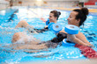 © Nejron Photo - Multiracial couple attending water aerobics class in a swimming pool