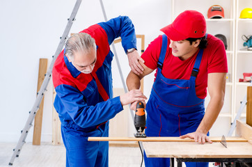 Two professional contractors laying flooring at home