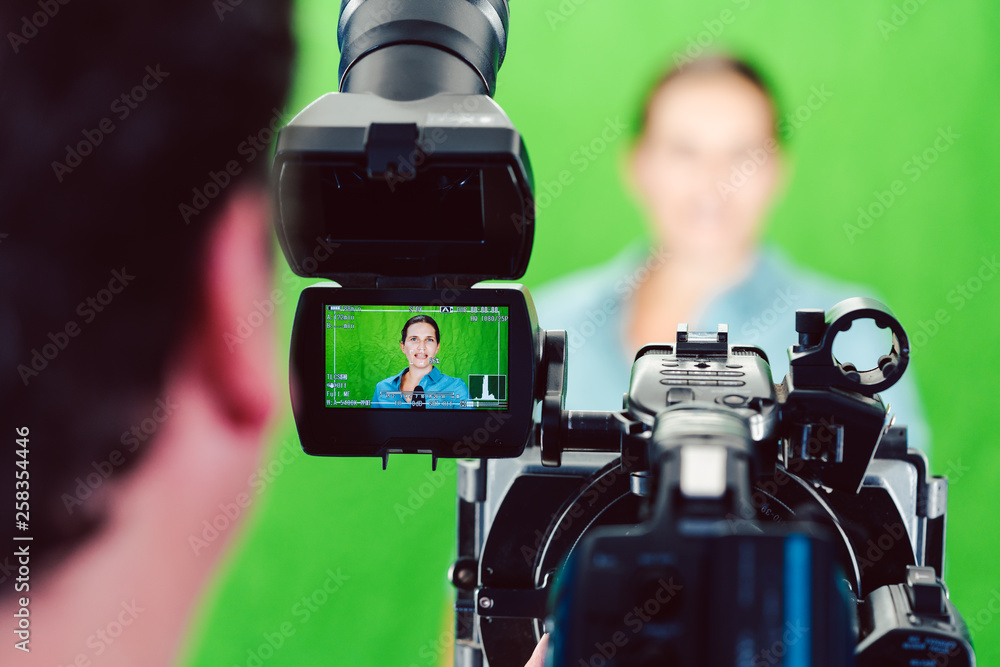 Kamera auf eine Nachrichtensprecherin oder Reporterin gerichtet bei einer Aufnahme im Studio  - obrazy, fototapety, plakaty 