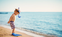 Three Years Old Boy Playing At The Beach With Swimming Ring