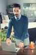 © Bojan - Young Indian business man starting or ending work day by opening or closing laptop in office