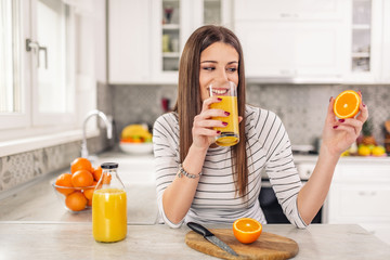 Close up Attractive Sensual Bare Woman drinking juice while Holding Sliced Orange Fruit.