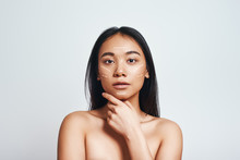 Perfect Skin. Portrait Of Beautiful Asian Woman Touching Her Skin And Looking At Camera While Standing On A Grey Background. Skin Care Concept