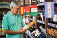 Consumer Man Choosing Wines In Supermarket. Brazilian Man.
