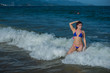 © Михаил Решетников - beautiful young woman in a seductive bikini comes out of the sea with high waves. Big waves in the ocean