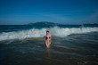 © Михаил Решетников - beautiful young woman in a seductive bikini comes out of the sea with high waves. Big waves in the ocean