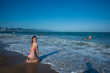 © Михаил Решетников - A young woman in a seductive bikini lying on the beach. Girl lying on the sand by the ocean