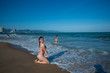 © Михаил Решетников - A young woman in a seductive bikini lying on the beach. Girl lying on the sand by the ocean