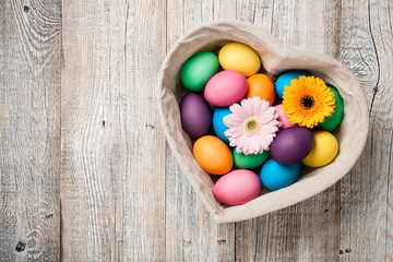 Canvas Print - Easter eggs and gerbera flowers in heart shaped basket