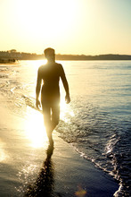 Silhouette Of Man, Walking At The Beach At Sunset