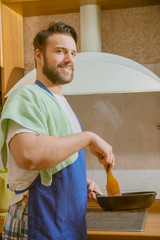 Wall Mural - a man cooks in the kitchen he cuts vegetables