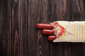 Wall Mural - spicy sausages in pita bread on wooden background.photo with copy space