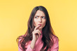 © GVS - Thoughtful confused woman looking away isolated over yellow background