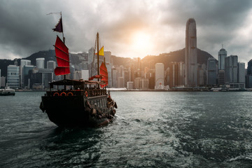 Fototapete - Hong Kong City skyline with tourist sailboat. View from across Victoria Harbor Hong Kong.