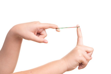 Child hand playing with elastic rubber band isolated on white